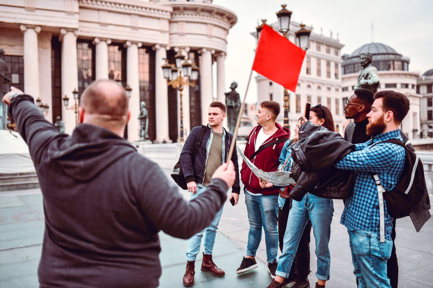 Tour Guide Showing Famous Buildings To Tourist Group